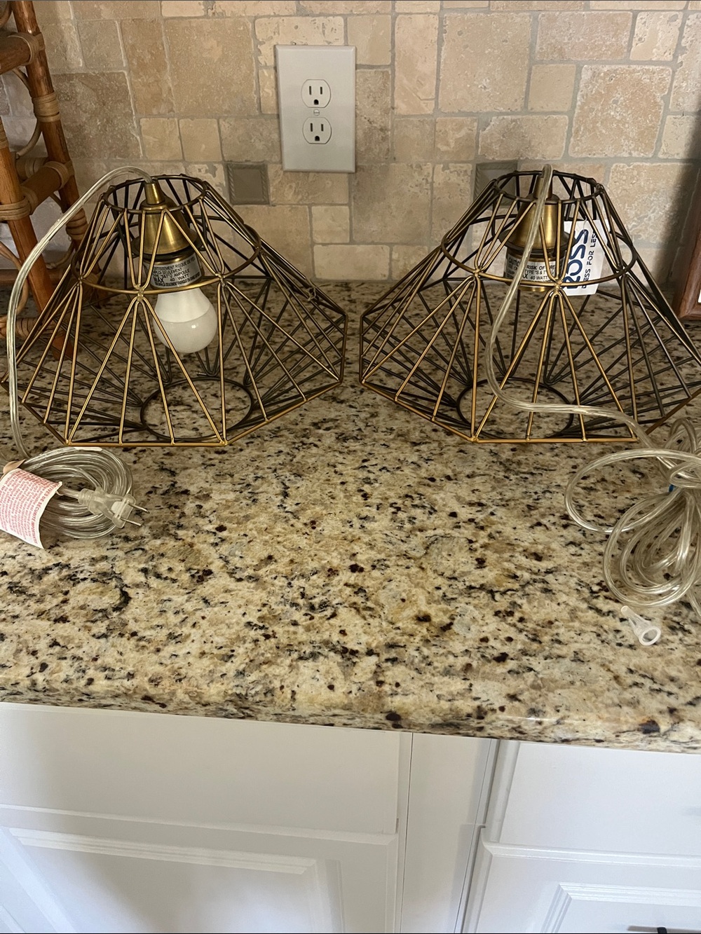 Two corded gold-tone metal hanging lamps.